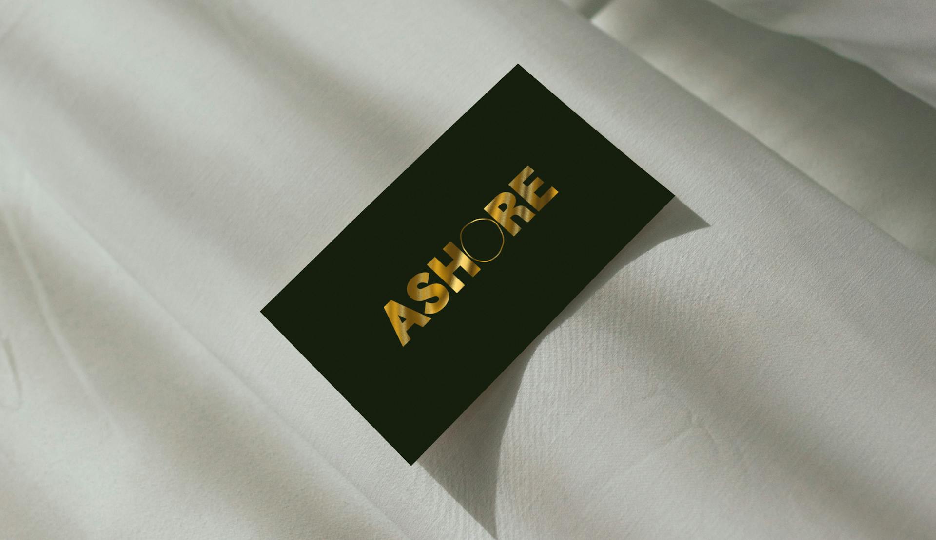 The Ashore gift card lying on a bed